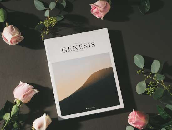 A copy of the book of Genesis surrounded by roses.