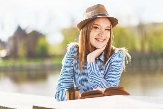 A woman relaxing and reading the Bible by a lake on the Sabbath.