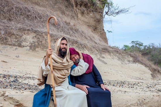 Jesus sitting next to a man and compassionately placing his arm around his head