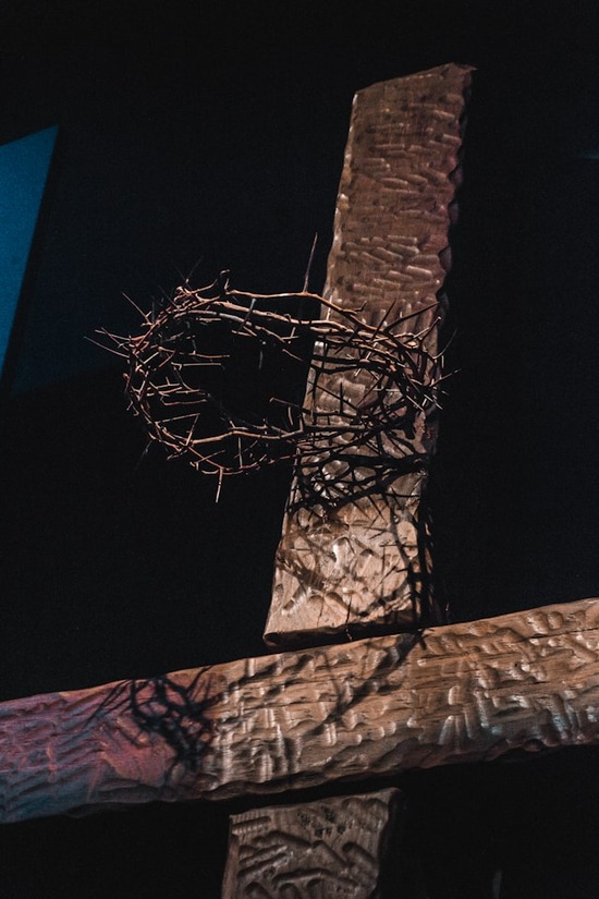 A crown of thorns hanging in front of a cross