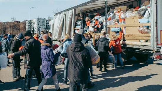 People stand in line to bring donations to a relief truck.