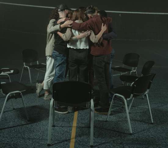 A group of Christian young adults huddled together in prayer