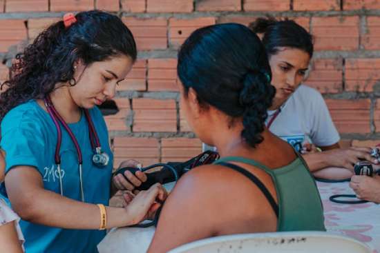 A nurse taking the blood pressure of a woman