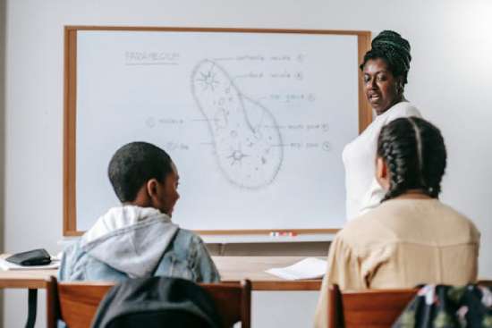 A teacher explaining biology to her students. Teachers are a defining point in Adventist schools