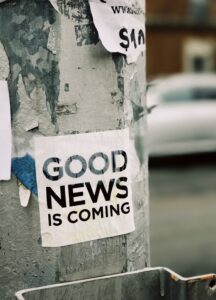  Posters attached to a post proclaiming that good news is coming.