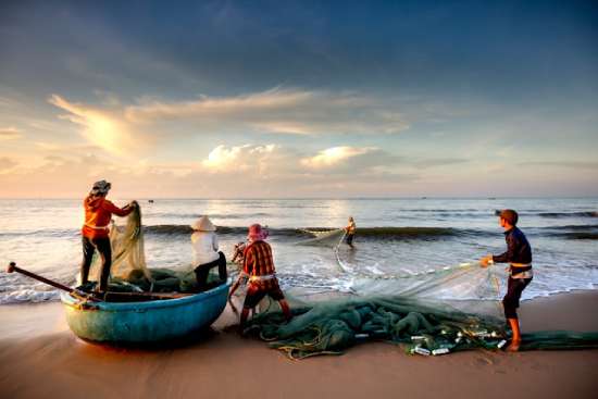 Fishermen pulling nets on the sea coast