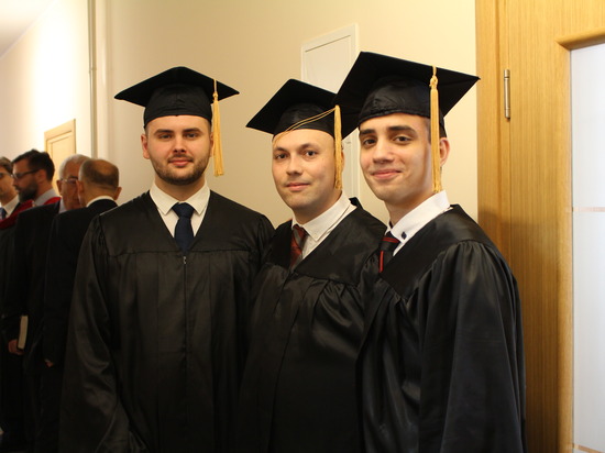 A group of theology students wearing graduation regalia at their graduation. 