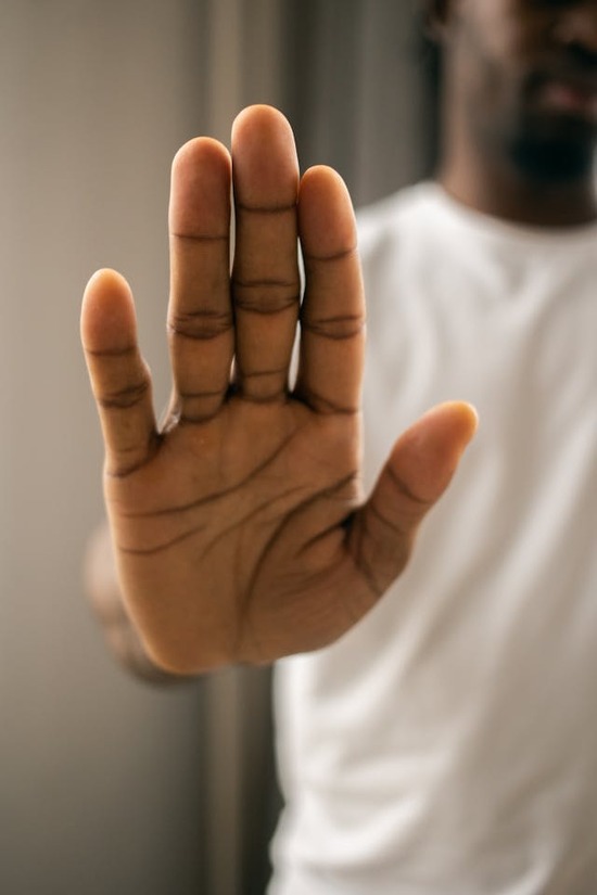 A man holding his hand out to tell someone to stop