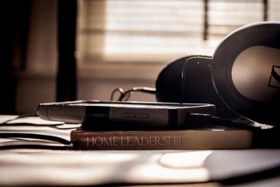 A pair of headphones and a phone sitting on top of a book