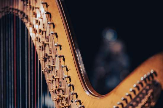 A close-up of a harp with a dark background. This harp, like the one David played for Saul, can produce music to calm the soul.