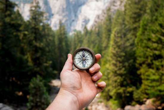 A person holding up a compass, symbolic of how sola scriptura can guide out beliefs