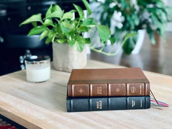 A King James Version and New King James Version of the Bible resting on top of one another on a desk