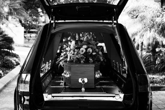 A hearse with a casket covered in flowers