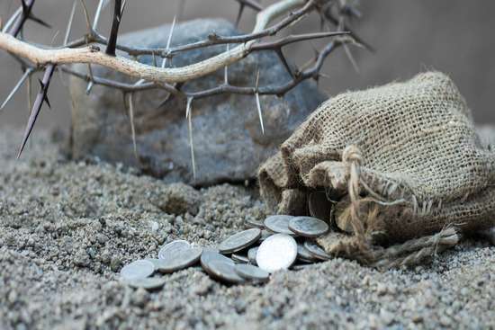 A small burlap sack with 30 pieces of silver spilling out