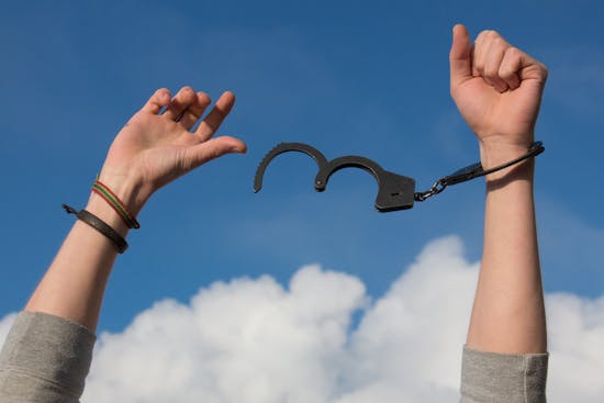 Hands breaking free from handcuffs