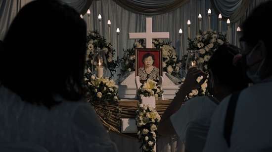 A casket decorated with flowers and a picture of the person who has died