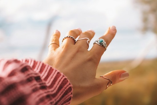 A woman's hand with a ring on each finger