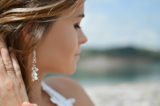 A woman pulling back her hair to reveal earrings as a sign of outward adornment