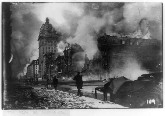 A black and white photo of a man patrolling the demolished streets of San Francisco after an earthquake.