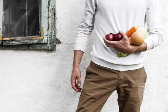 A man holds a variety of garden veggies, a foundational part of a healthy diet.