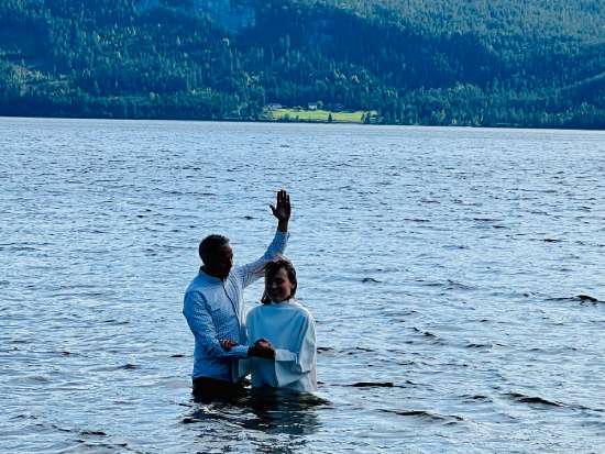 A pastor baptizing a woman who has chosen to follow Jesus