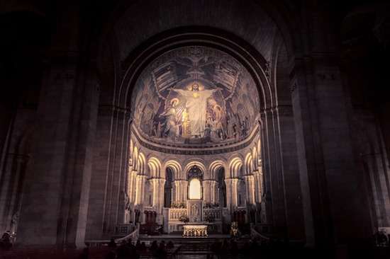 A giant cathedral with a mural of Jesus illuminated