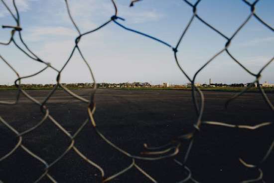 A chain link fence with a hole in it, symbolizing the barrier Jesus broke