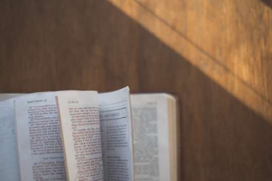 Bible pages flipping open to the Gospel accounts of Jesus' baptism