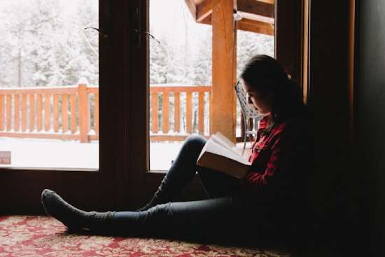 A woman sitting on the floor studying her Bible