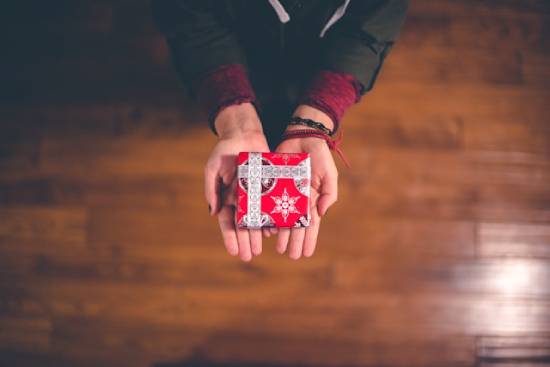 Someone holds out a small, wrapped box, illustrating how salvation is offered to us as a gift.